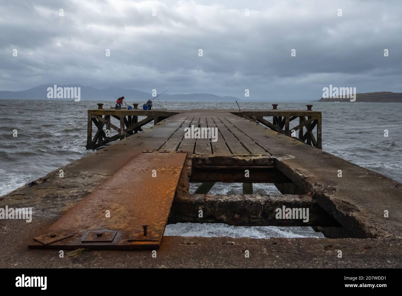 Portencross, Scozia, Regno Unito. 25 ottobre 2020. Regno Unito Meteo: La gente pesca dal molo di Portencross con l'Isola di Arran (a sinistra) e l'Isola di Little Cumbrae (a destra) sullo sfondo. Credito: SKULLY/Alamy Live News Foto Stock