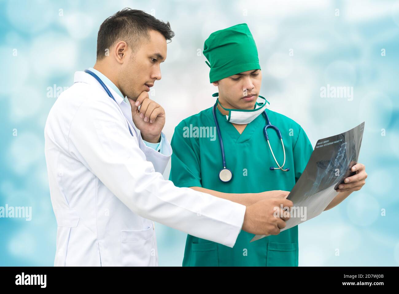 Medico e chirurgo che guarda la pellicola di raggi X, diagnosticare la malattia del paziente nell'ospedale. Concetto medico. Foto Stock