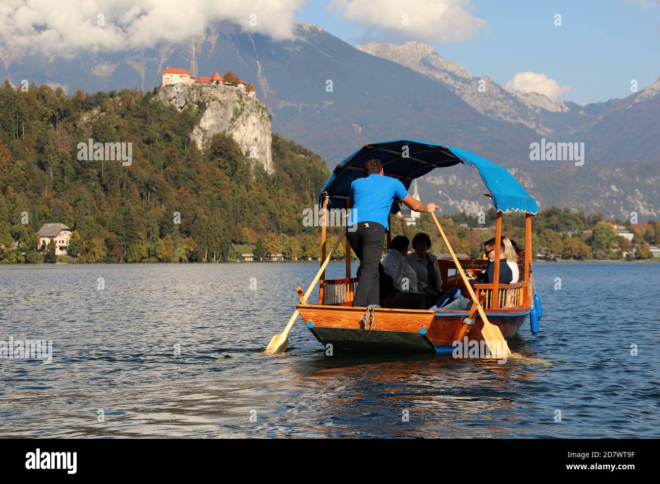 Turisti che viaggiano in pletna tradizionale sul Lago di Bled in Slovenia Foto Stock
