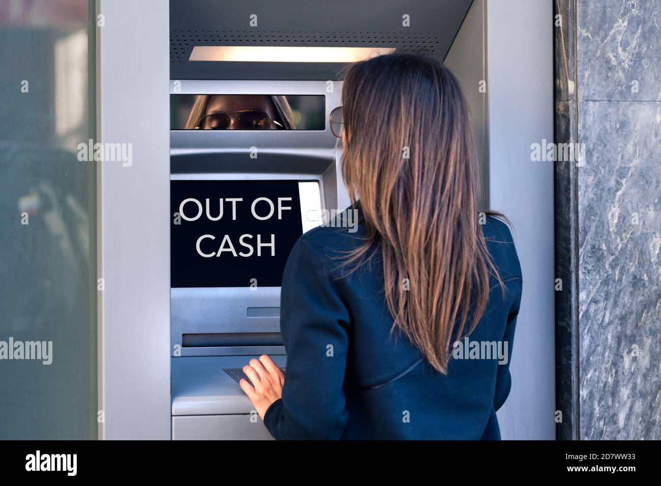 Donna cerca di prendere denaro contante da una macchina ATM. Il bancomat è fuori contanti, nessun denaro. Impossibile prelevare denaro contante dalla carta di credito presso la macchina bancaria. Foto Stock