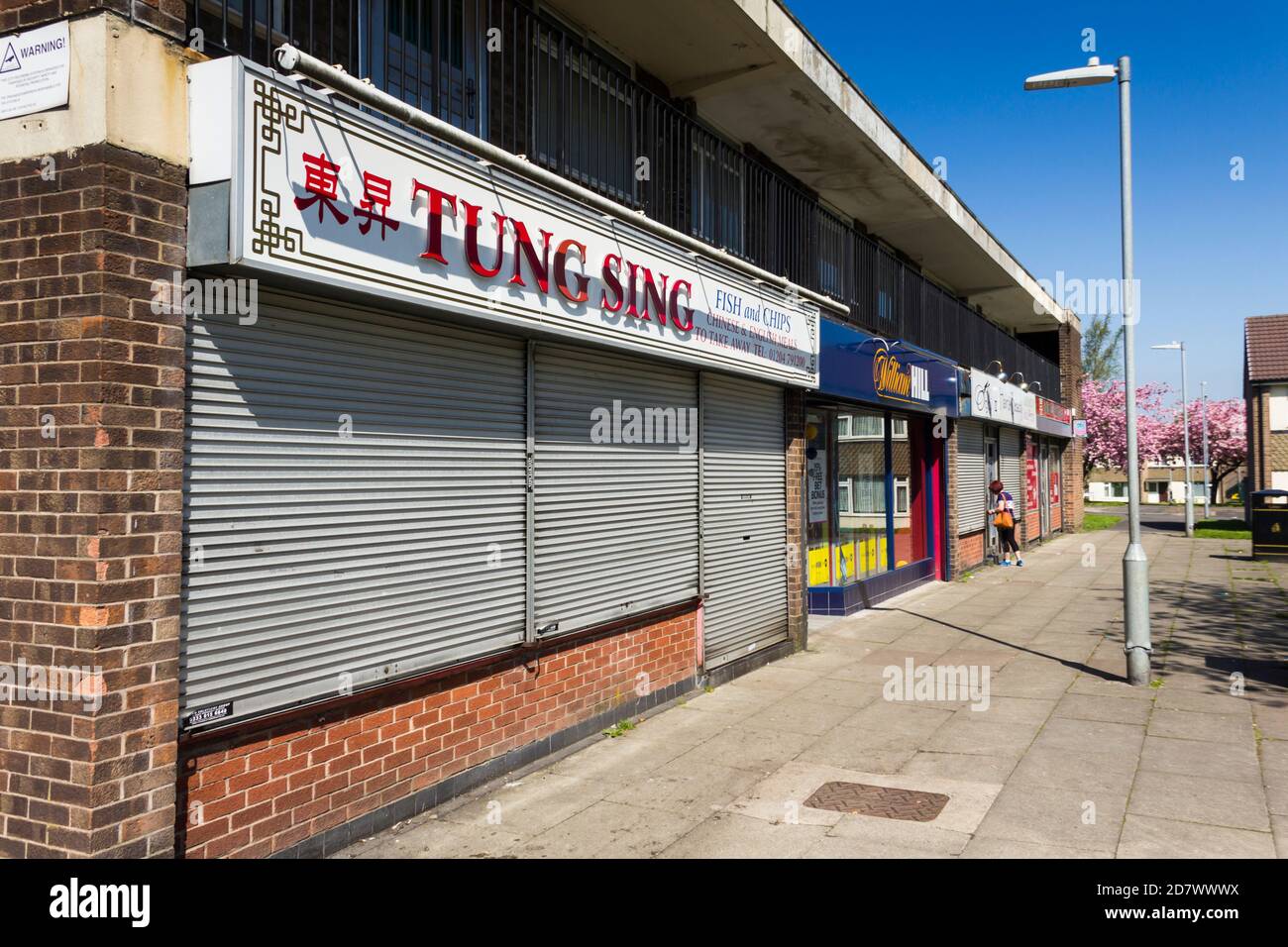 Sfilata di negozi locali su Glynne Street, Farnworth. Con un takeaway cinese e Fish & chip, un negozio di scommesse, parrucchiere e salone di bellezza e un'edicola Foto Stock