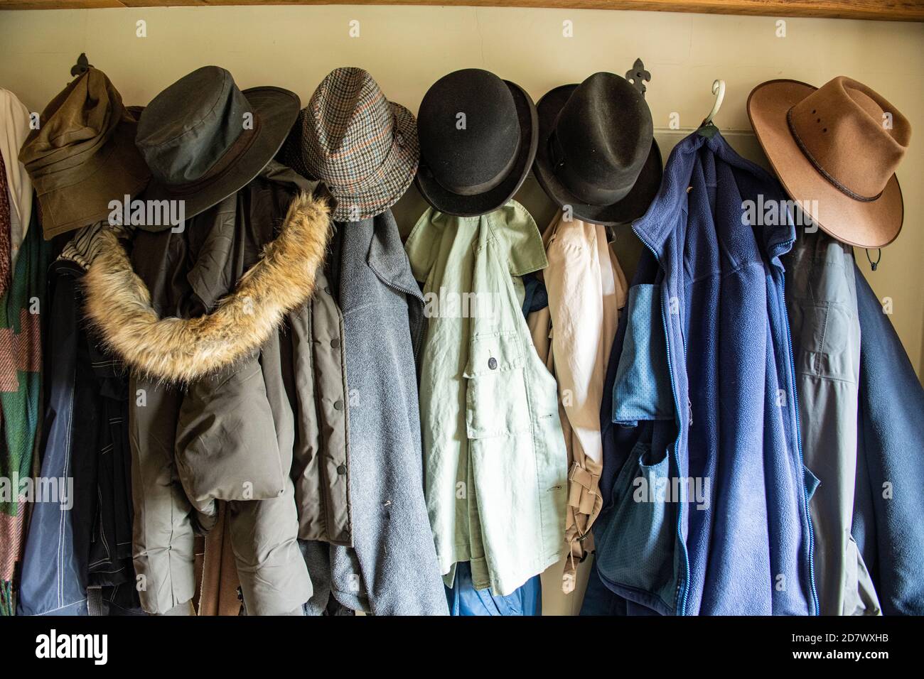 Una selezione di cappelli e cappotti appesi in un corridoio Foto Stock