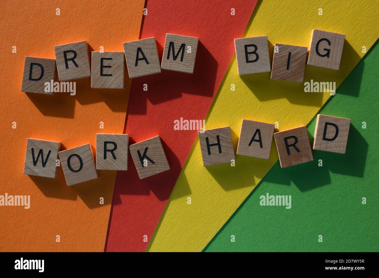 Dream Big, lavoro duro, parole in lettere alfabetiche in legno su sfondo colorato Foto Stock