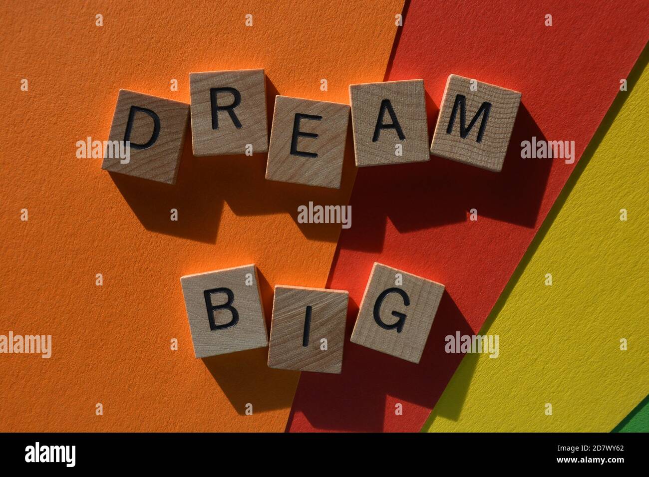 Dream Big, parole in lettere alfabetiche in legno su sfondo colorato Foto Stock