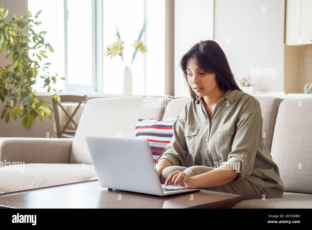 Giovane donna indiana che usa un computer portatile che lavora in ufficio. Foto Stock