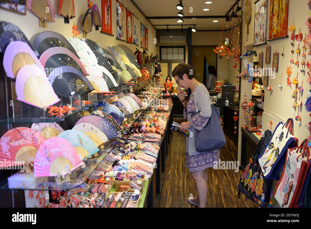 Un turista occidentale che guarda i fan giapponesi della carta e le opere d'arte, Kyoto JP Foto Stock