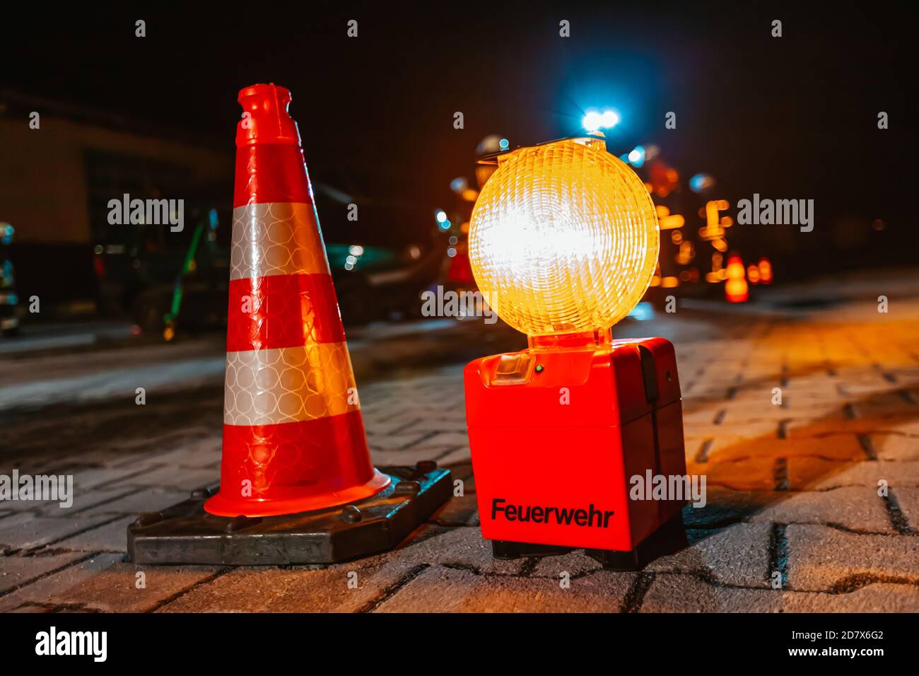 La luce di ingombro al suolo si trova vicino a un incidente. Feuerwehr è la parola tedesca per vigili del fuoco Foto Stock