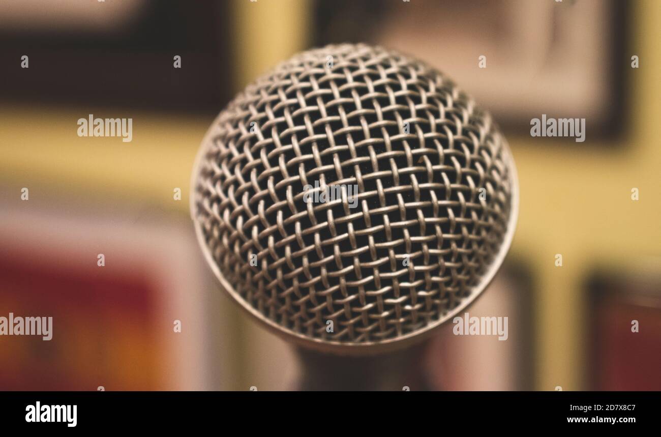 Primo piano su un microfono in metallo, con uno sfondo sfocato Foto Stock