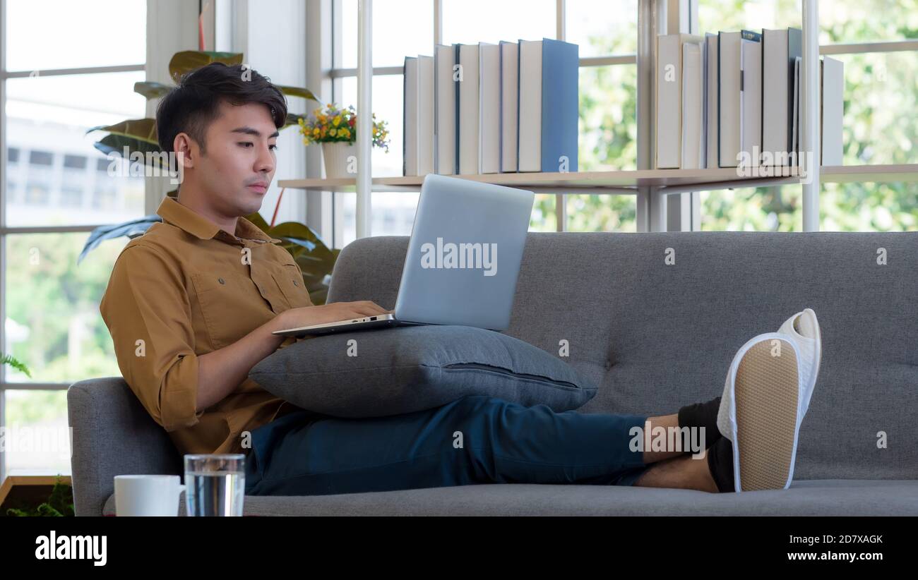 Uomo asiatico che lavora a casa Foto Stock