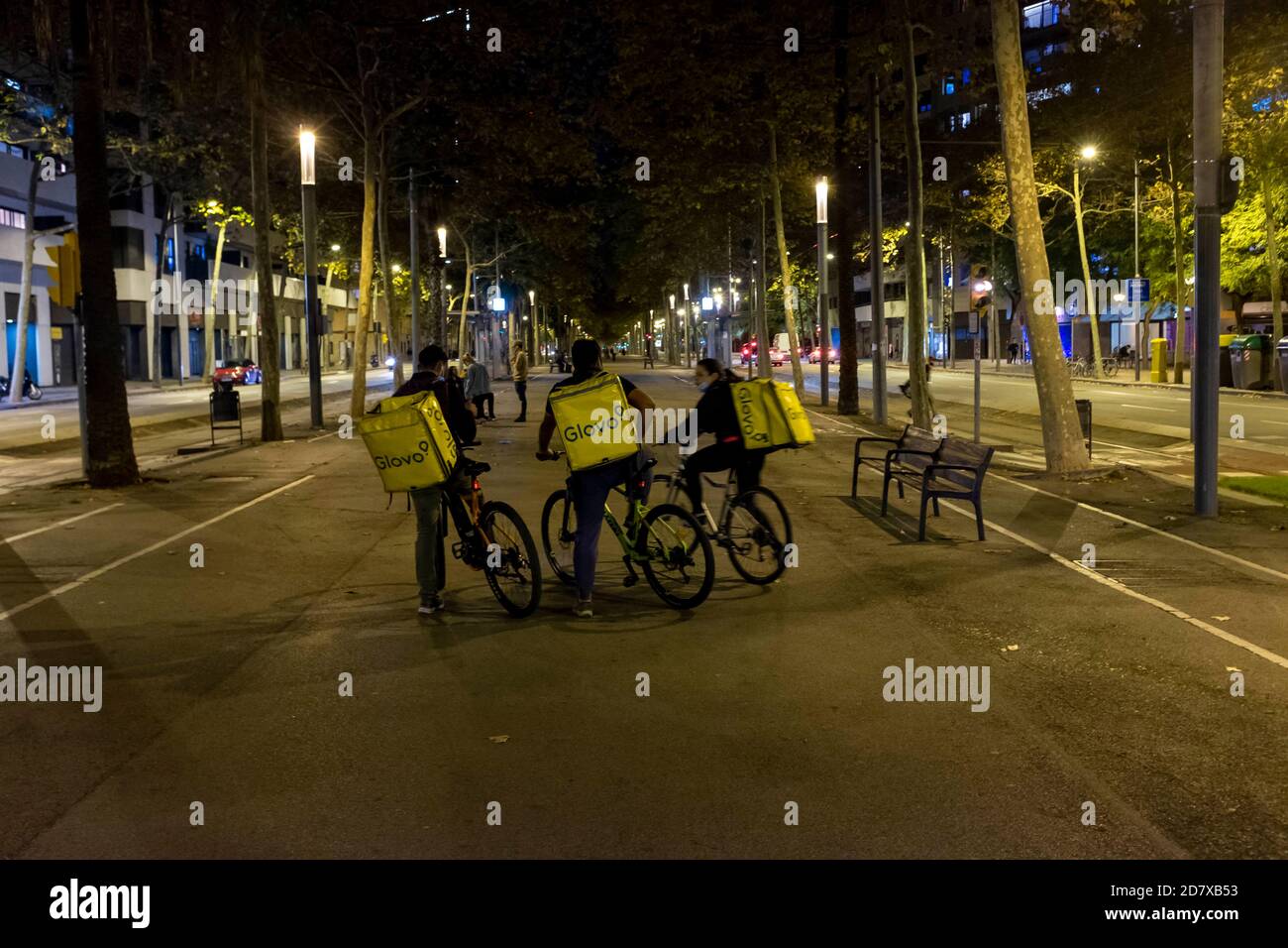 Barcellona, Catalogna, Spagna. 25 ottobre 2020: Glovo deliverymen, sulla Diagonal nella sua sezione che va dalla Plaza de las Glorias al Forum momenti prima della prima notte del coprifuoco di Barcellona. Il governo della Generalitat de Catalunya ha deciso di attivare una restrizione alla mobilità notturna o al coprifuoco tra le 10 e le 6, che entra in vigore questa stessa notte sotto la protezione dello Stato di allarme approvato dal Consiglio straordinario dei Ministri questa domenica. "Tutti i movimenti e la circolazione su strade pubbliche sono vietati" in questa striscia, interessa gli interni. (Foto Foto Stock