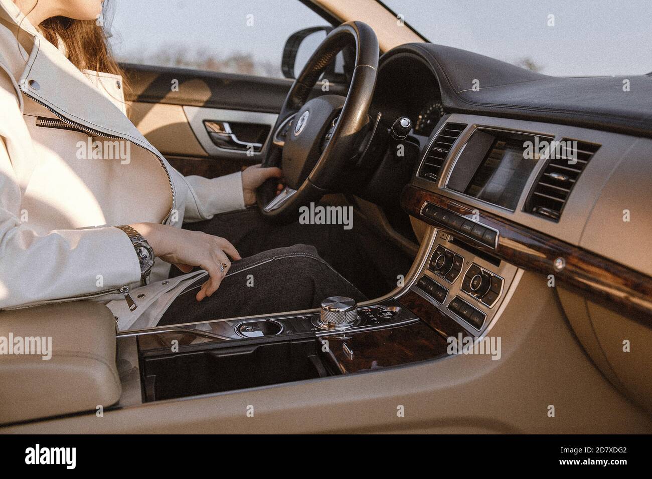 Salone auto in pelle beige. Donna che guida una macchina. Foto Stock