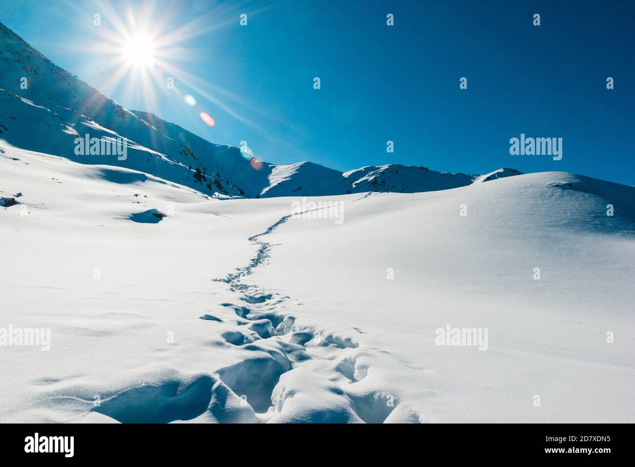 Orme nel paesaggio delle montagne innevate. Bellissima alba invernale. Avventura e tempo di viaggio Foto Stock