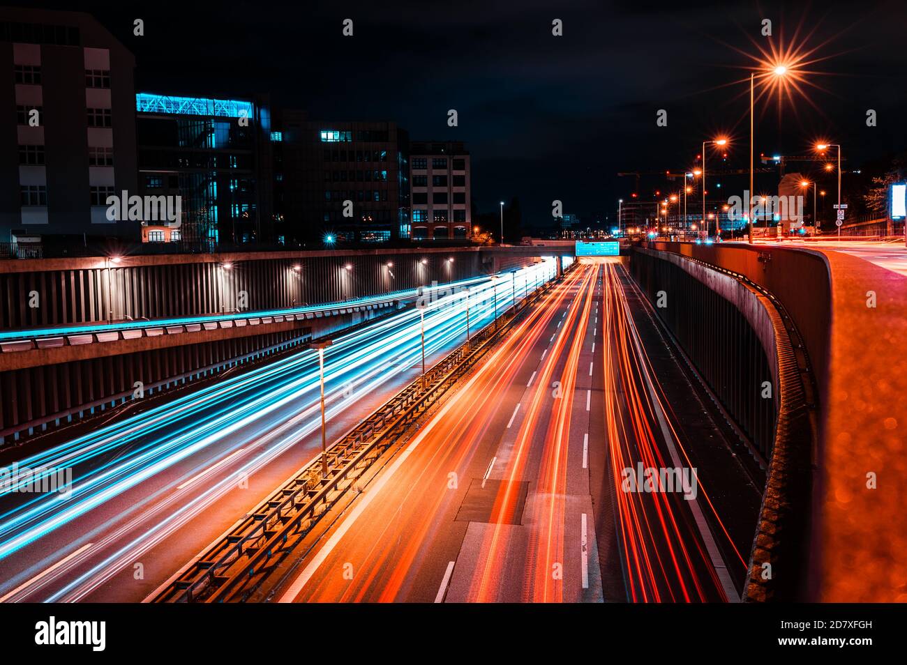 Notte lunga esposizione di Berlino Tempelhof zona urbana autostrada Autobahn in città. Ampia autostrada, tracce di luci dei fari dei veicoli. Movimento Foto Stock