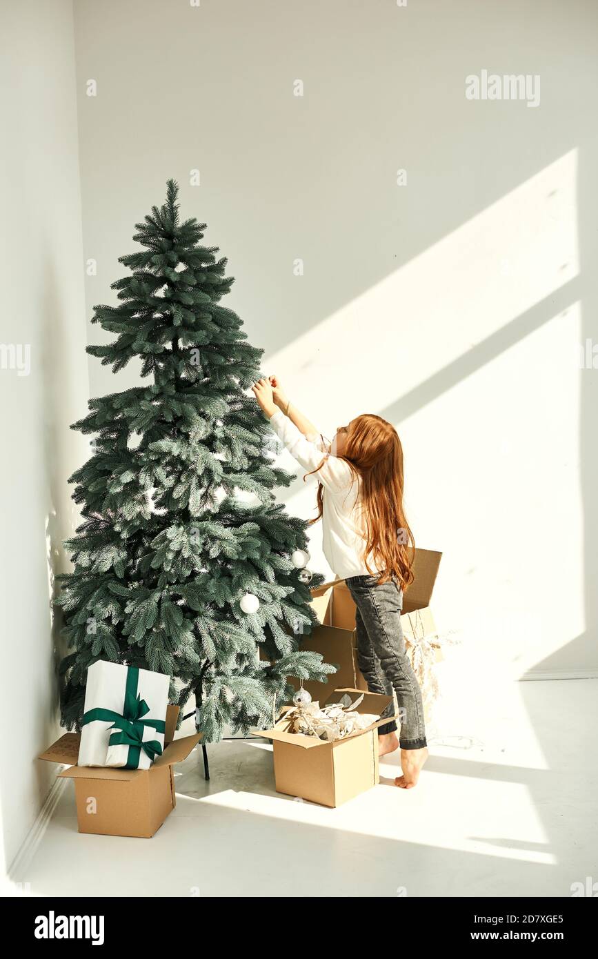 Una bambina decorata albero di Natale su un bianco Foto Stock