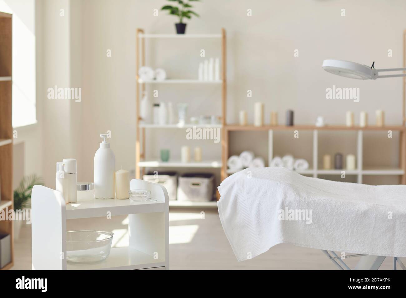 Salone Spa con set di prodotti naturali per la cura della pelle, letto vuoto e asciugamani freschi Foto Stock