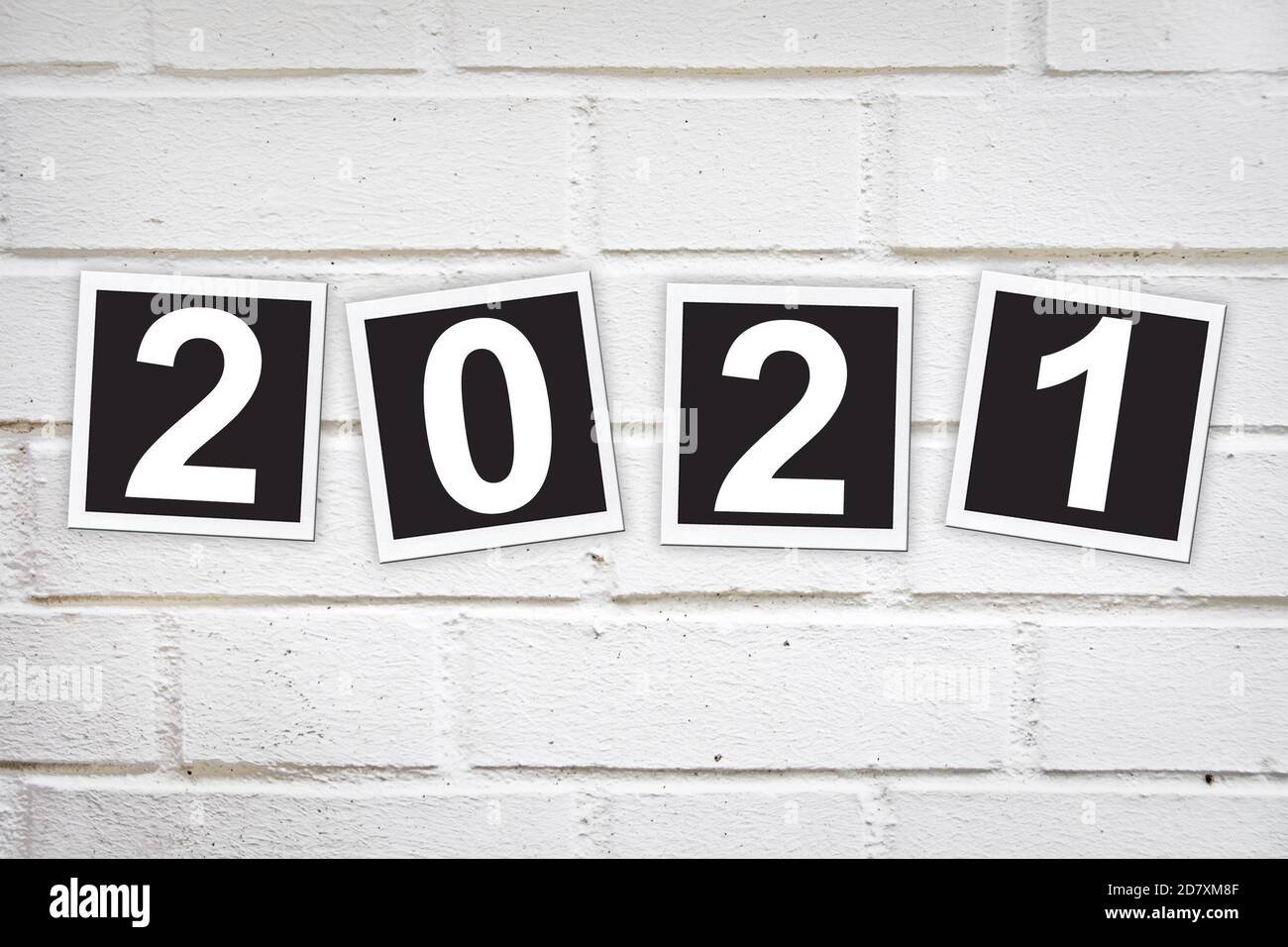 2021 in cornici fotografiche istantanee su una parete di mattoni, biglietto d'auguri di nuovo anno Foto Stock