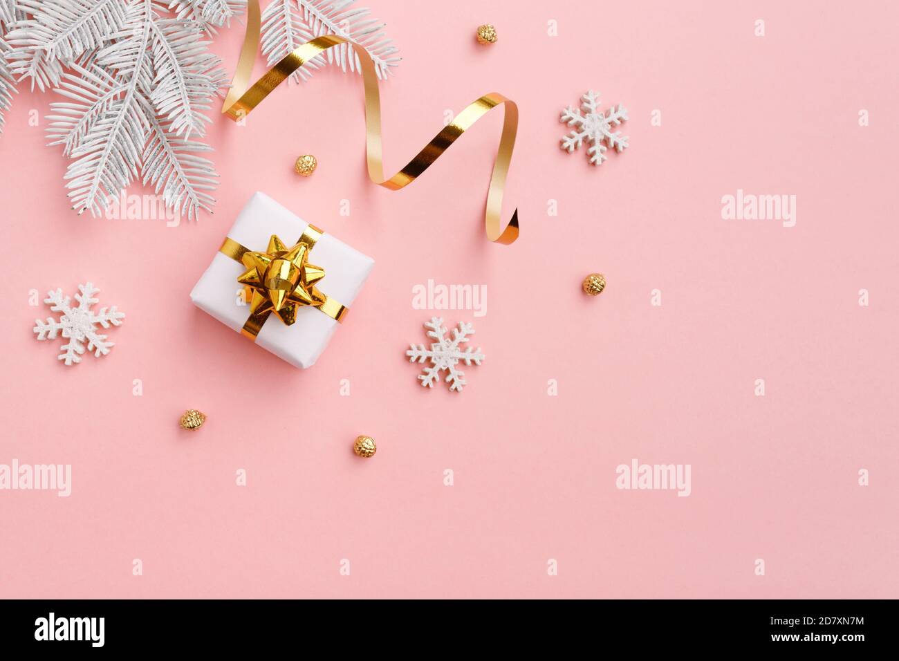 Ornamento natalizio con decorazioni in oro su sfondo rosa pastello Foto Stock
