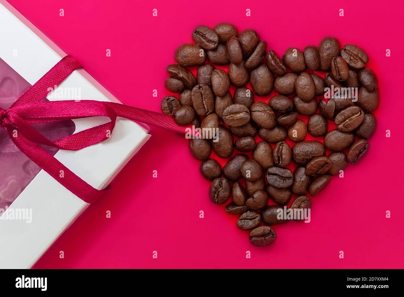 Cuore di caffè, chicchi di caffè tostati e cioccolato. Concetto di San Valentino, buon umore, endorfine, biglietti d'auguri. Foto Stock