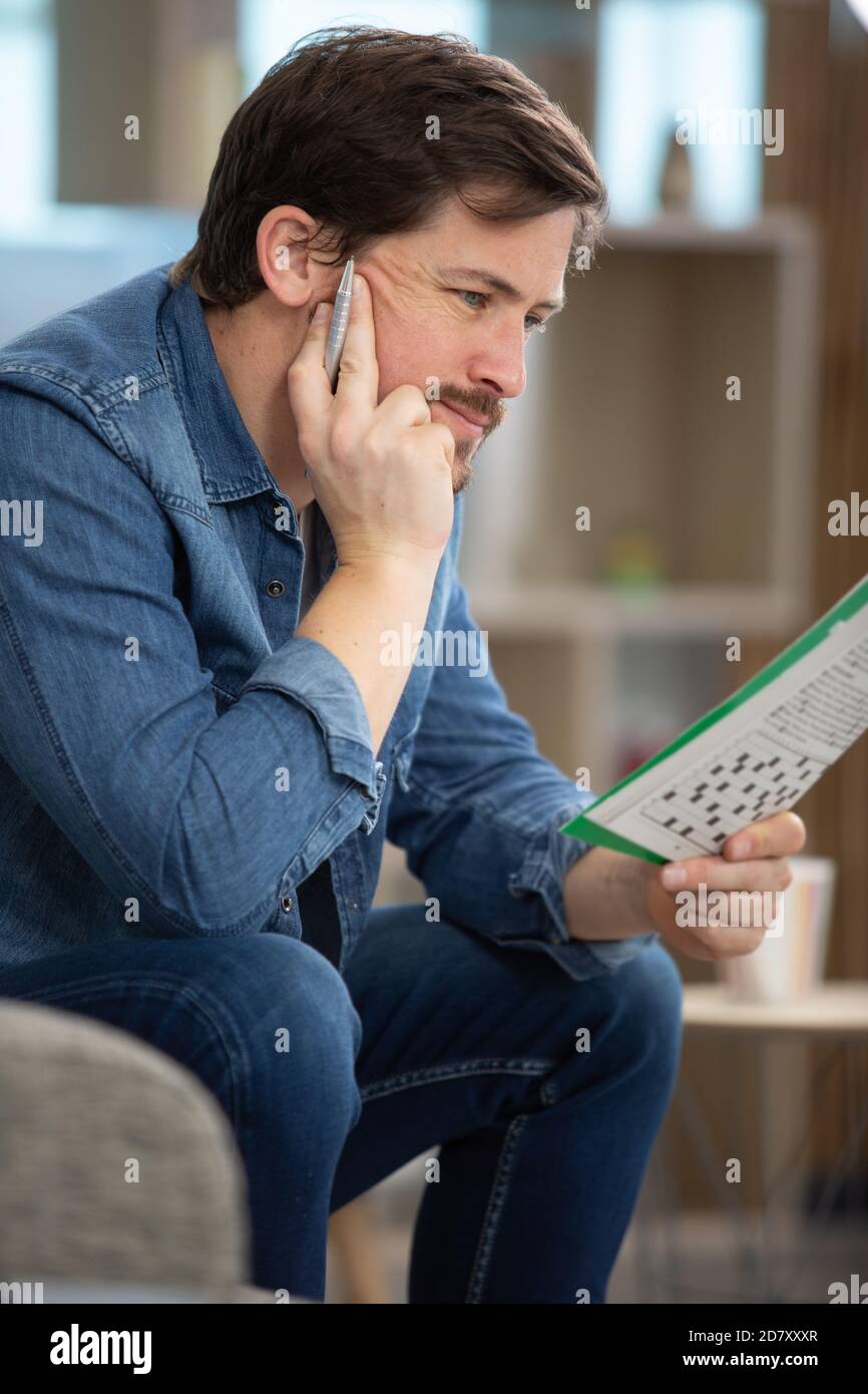 giovane uomo che fa un puzzle crossword Foto Stock