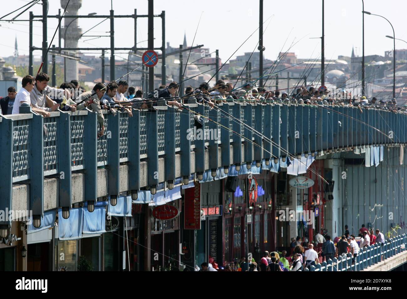 Centinaia di pescatori gettano le loro linee nel Corno d'Oro dal Ponte di Galata a Istanbul, in Turchia. La pesca è un passatempo preferito dai turchi. Foto Stock