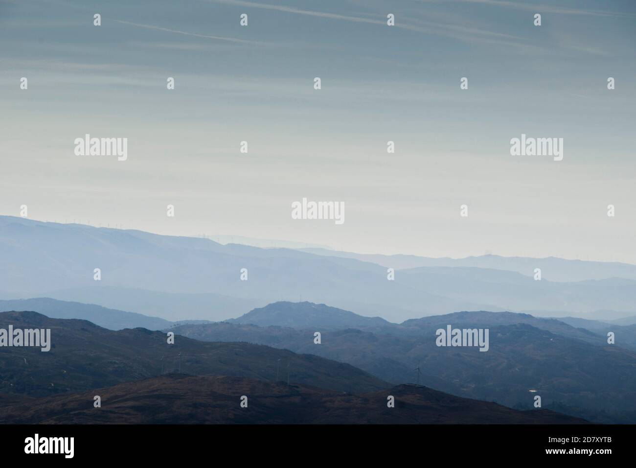 Le forme e le curve delle montagne svaniscono nell'orizzonte sottostante la nebbia mattutina Foto Stock