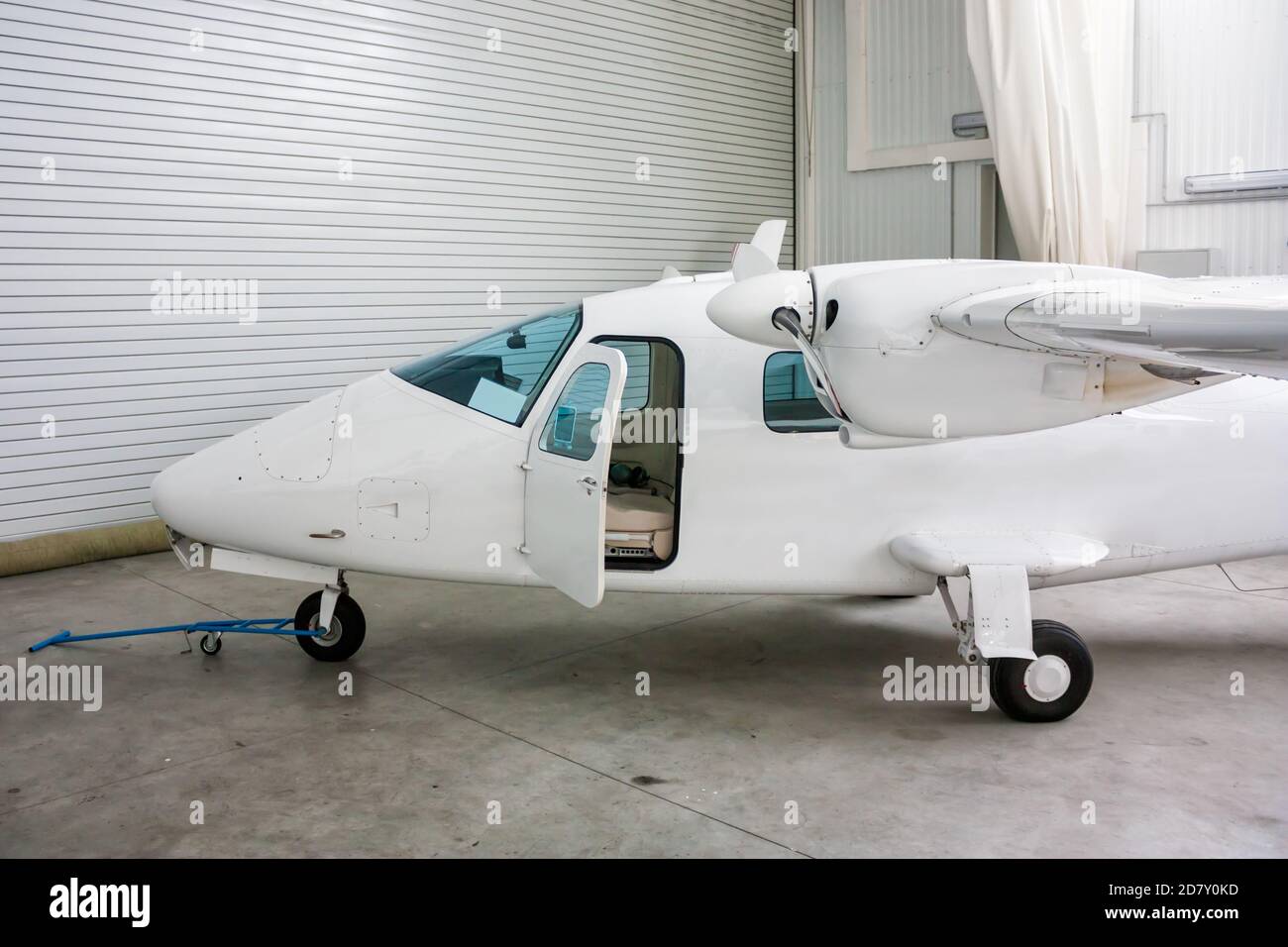 Velivolo leggero ad alata doppia con porta aperta in hangar Foto Stock