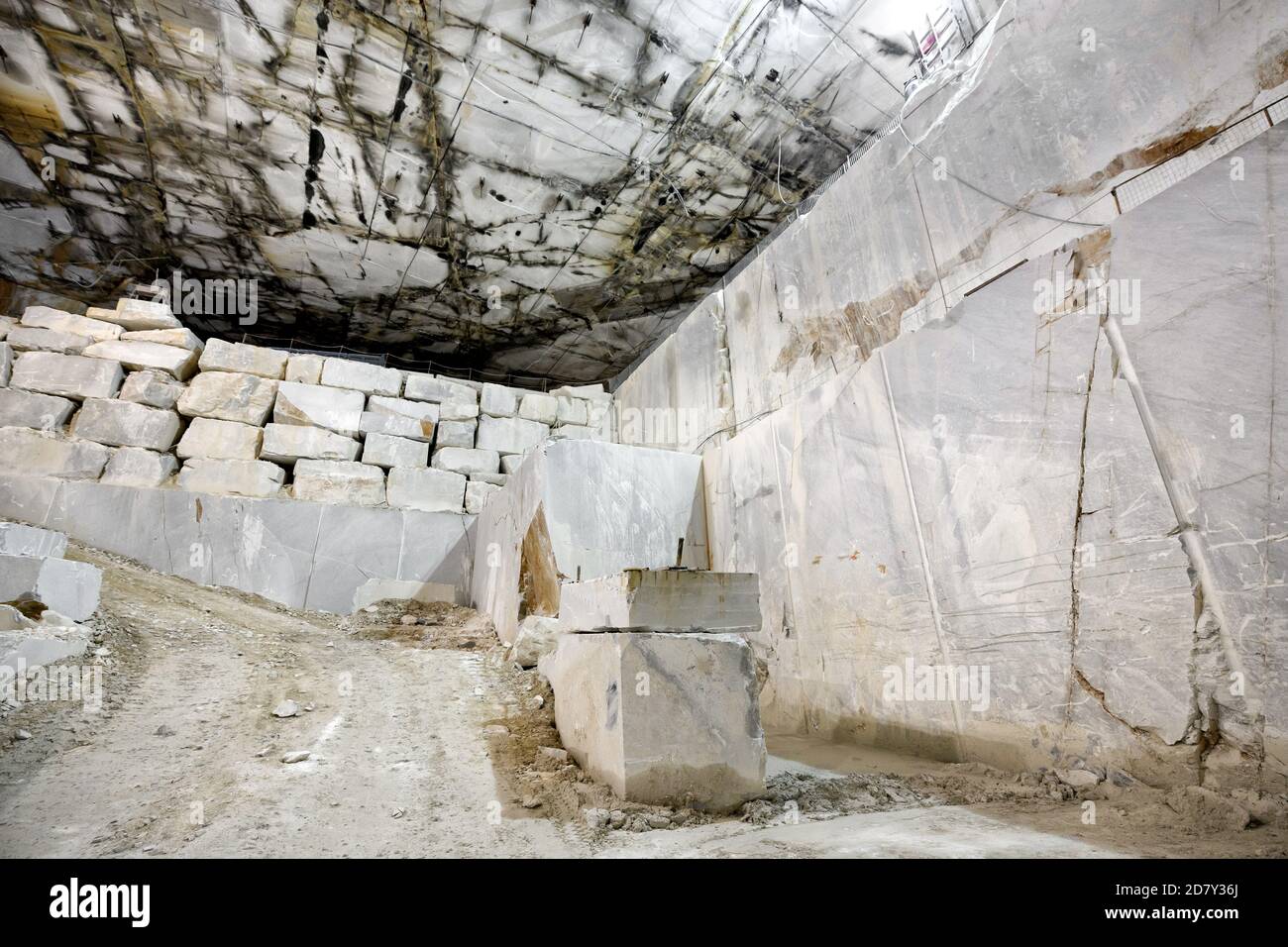 Vista panoramica della parete rocciosa e dei blocchi di marmo tagliati in una cava o miniera a cielo aperto a Carrara, Toscana, Italia durante l'estrazione della roccia da A. Foto Stock