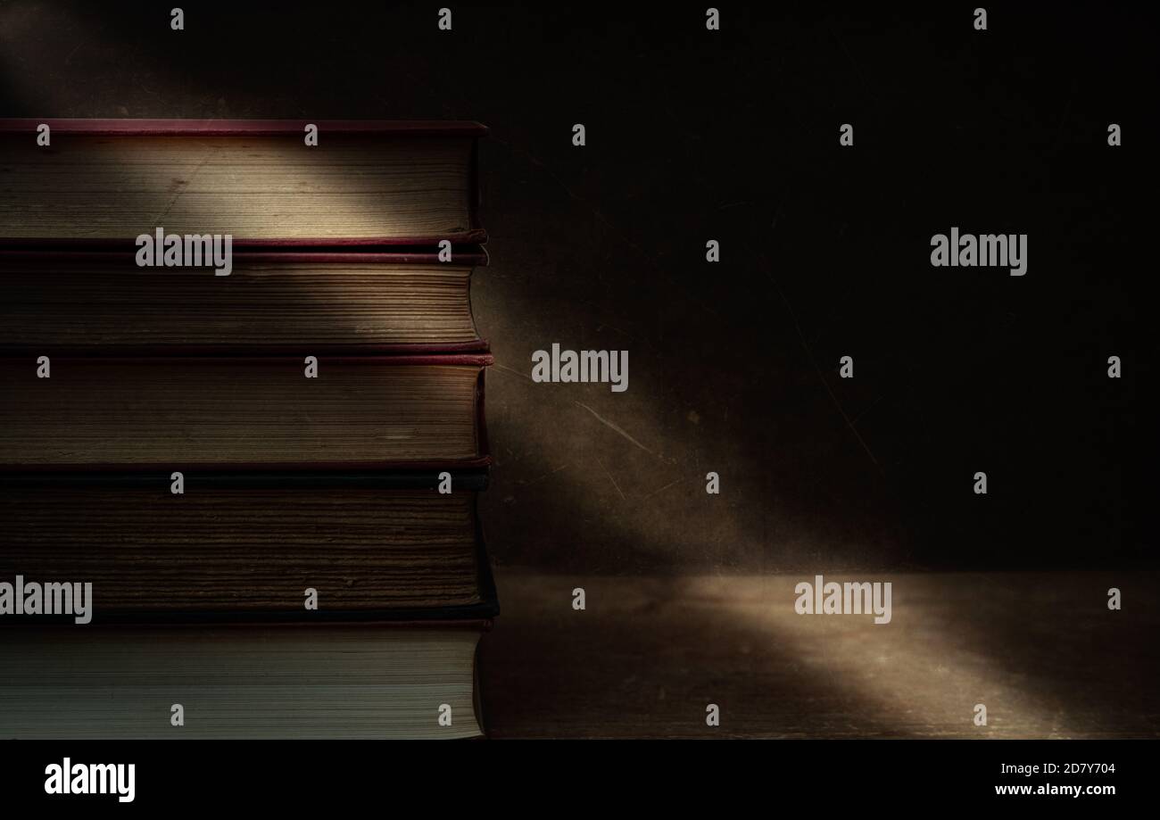 vecchi libri accatastati su tavolo, moody con spazio per il testo, concetto di passsing del tempo . Foto Stock