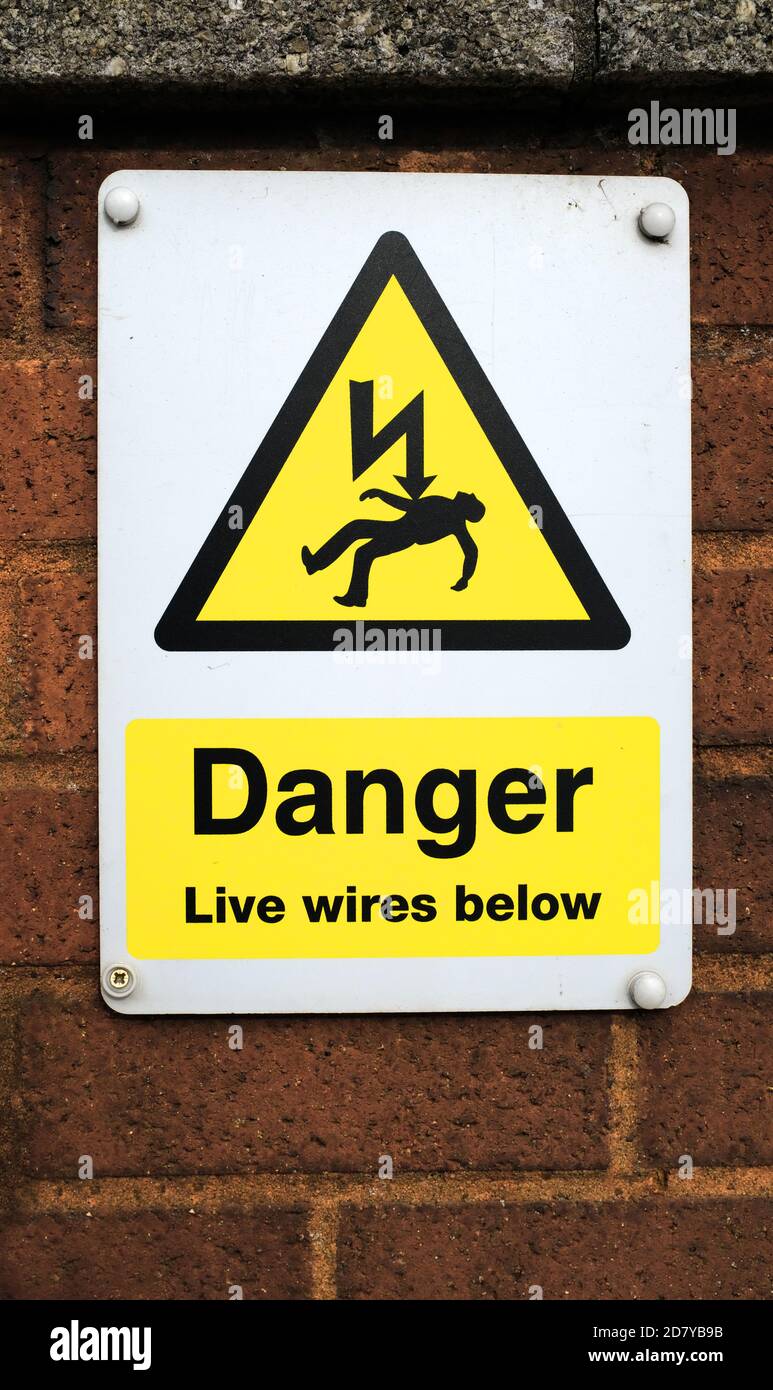 Un segnale di pericolo elettrico presso una stazione ferroviaria, Inghilterra Foto Stock