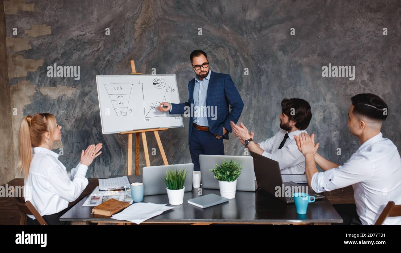 Uomini d'affari anziani e giovani applaudono l'uomo d'affari dopo la presentazione alla riunione della conferenza, il gruppo grata che batte le mani acclamando il team sorridente Foto Stock