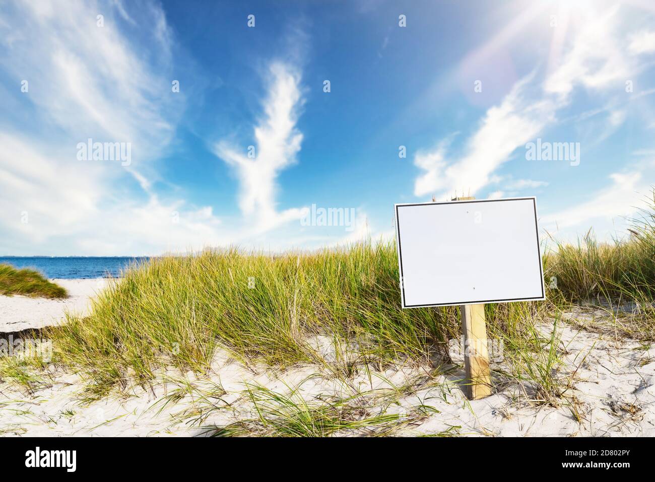 segnavia con spazio di copia su ampia spiaggia di sabbia contro il mare e cielo blu Foto Stock