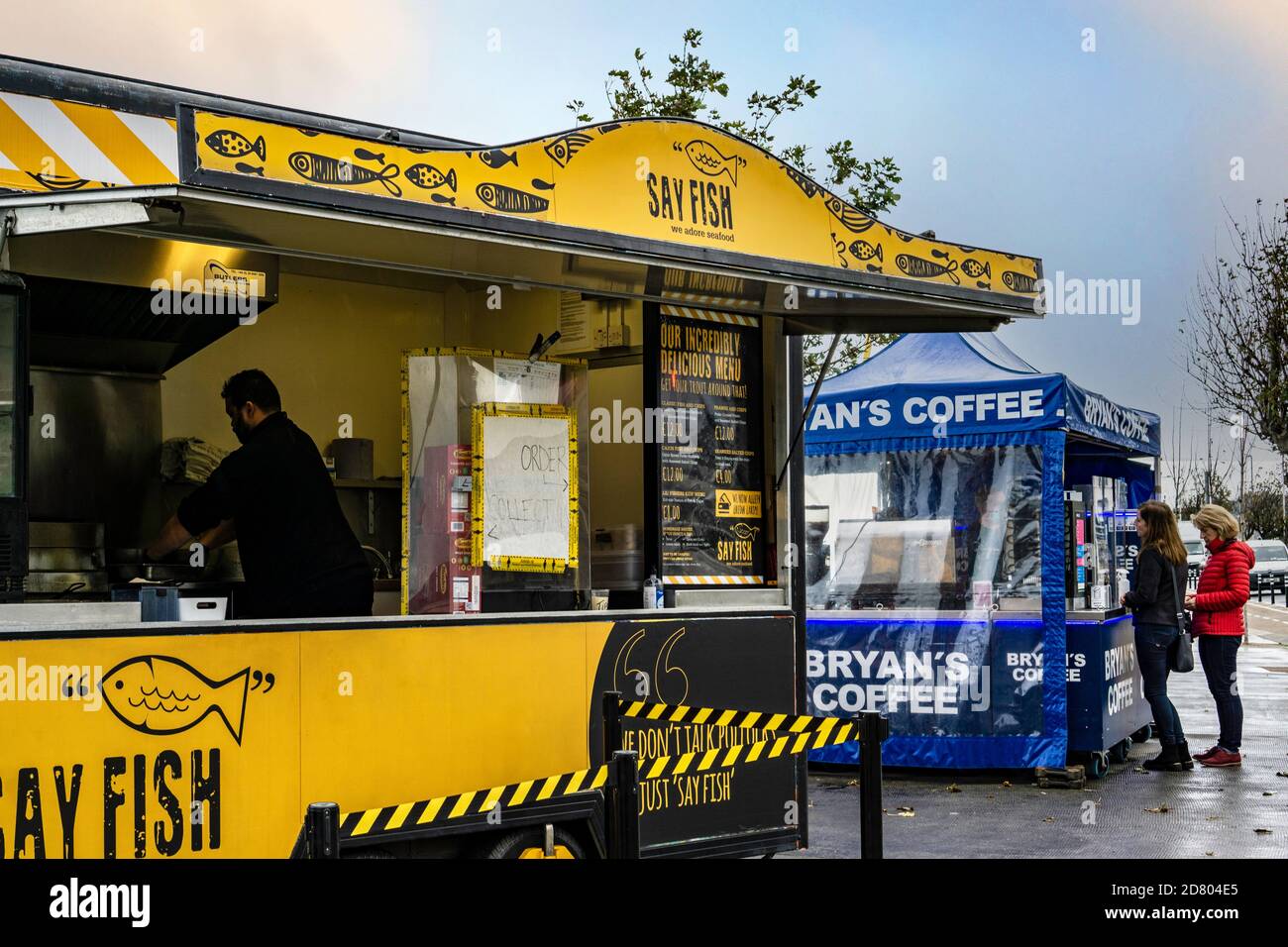Pesca e take away. Sul molo di Dun Laoghaire a Dublino, Irlanda, un pesce e chip take away e una coda per il caffè. Foto Stock