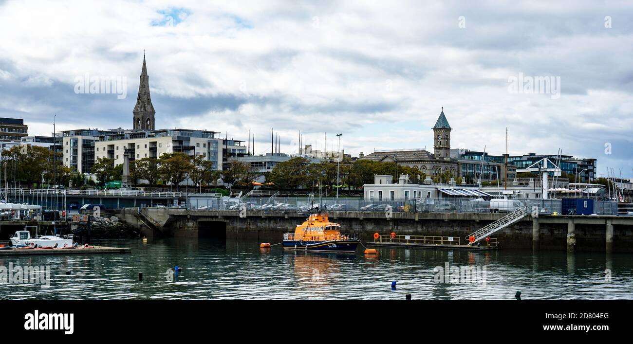 Il paesaggio urbano di Dun Laoghaire, Dublino, Irlanda con la Lifeboat RNLI a prua e le torri della chiesa e la città sullo sfondo. Foto Stock