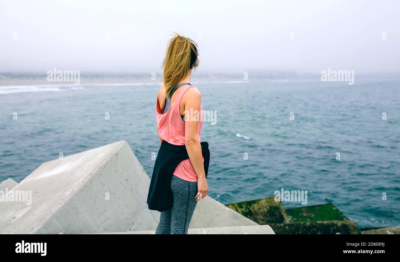 Irriconoscibile giovane donna guardando il mare Foto Stock