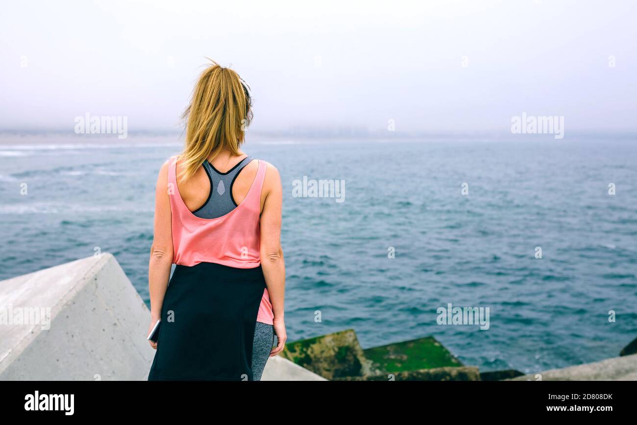 Irriconoscibile giovane donna guardando il mare Foto Stock