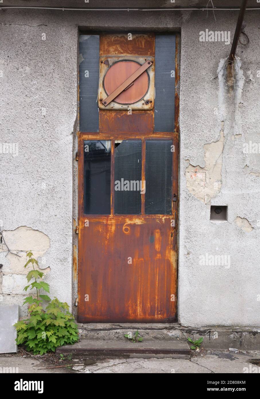 Cracovia. Cracovia. Polonia. Chiusa porta di ferro arrugginita che porta all'edificio abbandonato. Foto Stock