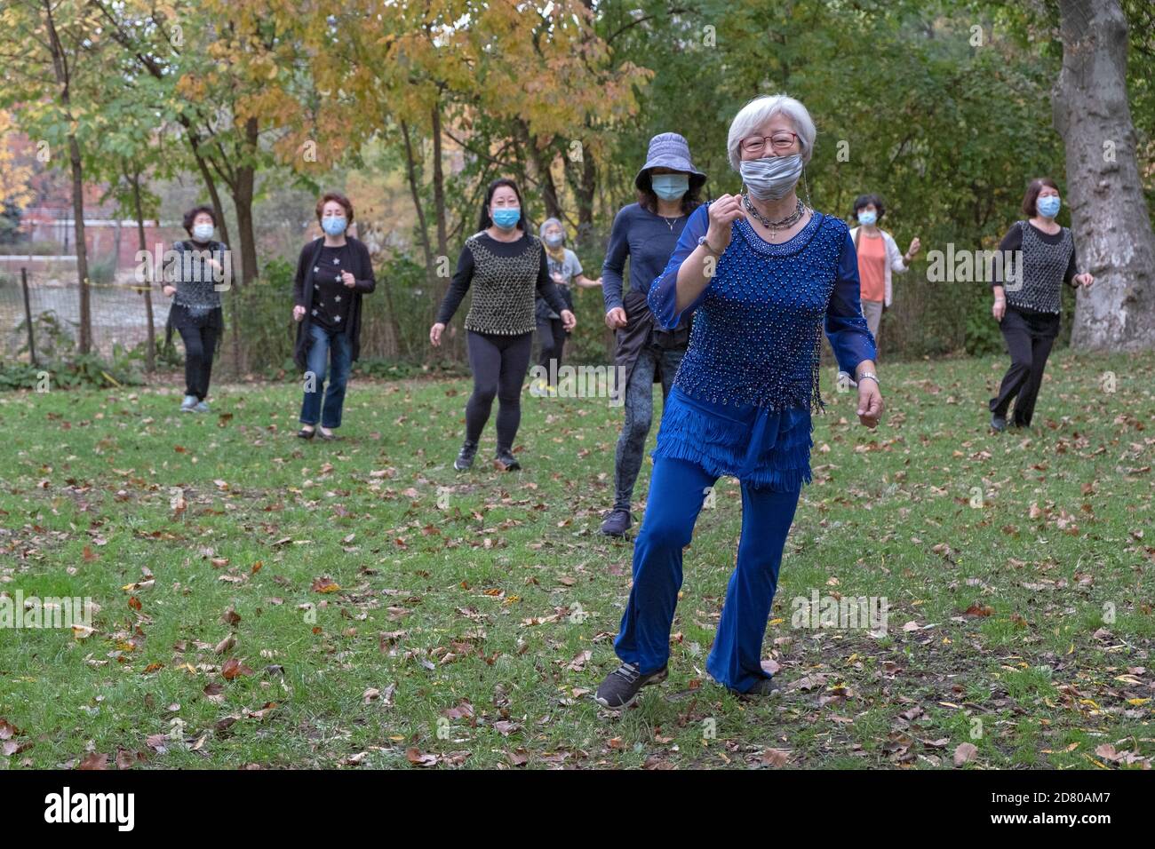 Un gruppo di donne asiatiche americane di tutte le età indossa maschere e distanza sociale. In una lezione di danza in un parco a Flushing, Queens, New York City. Foto Stock