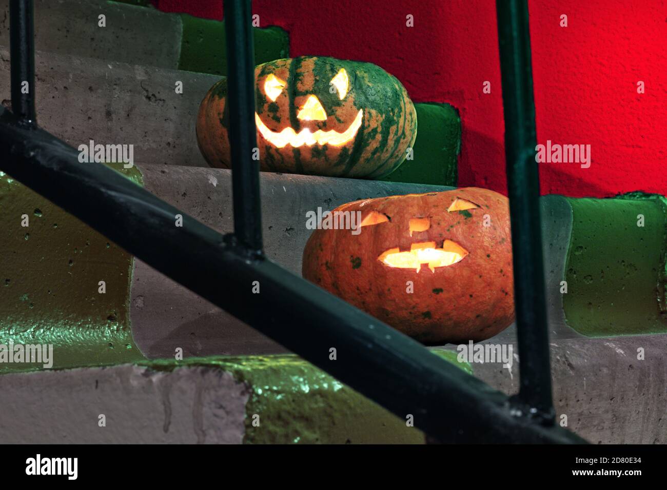 due jack-o'-lanterna. Belle zucche sulle scale dietro le barre delle ringhiere Foto Stock
