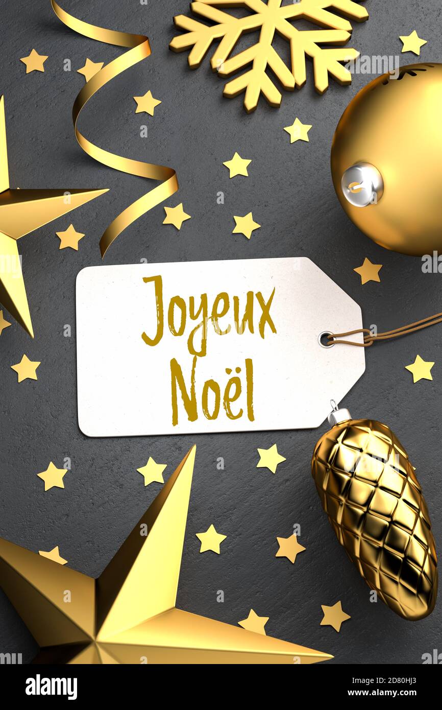 Natale - Tag regalo con il messaggio francese di Natale 'Joyeux Noël' su uno sfondo di pietra nera con ornamenti di natale color oro intorno. Foto Stock