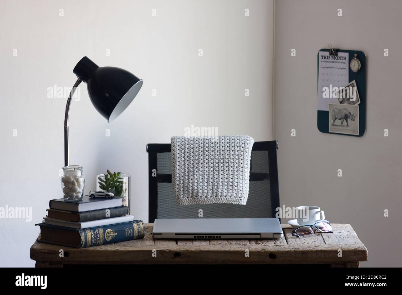 Uno spazio di lavoro per l'ufficio domestico con una scrivania in legno rigenerata, organizzata e pronta per essere utilizzata per lavorare in modo produttivo da casa. Foto Stock