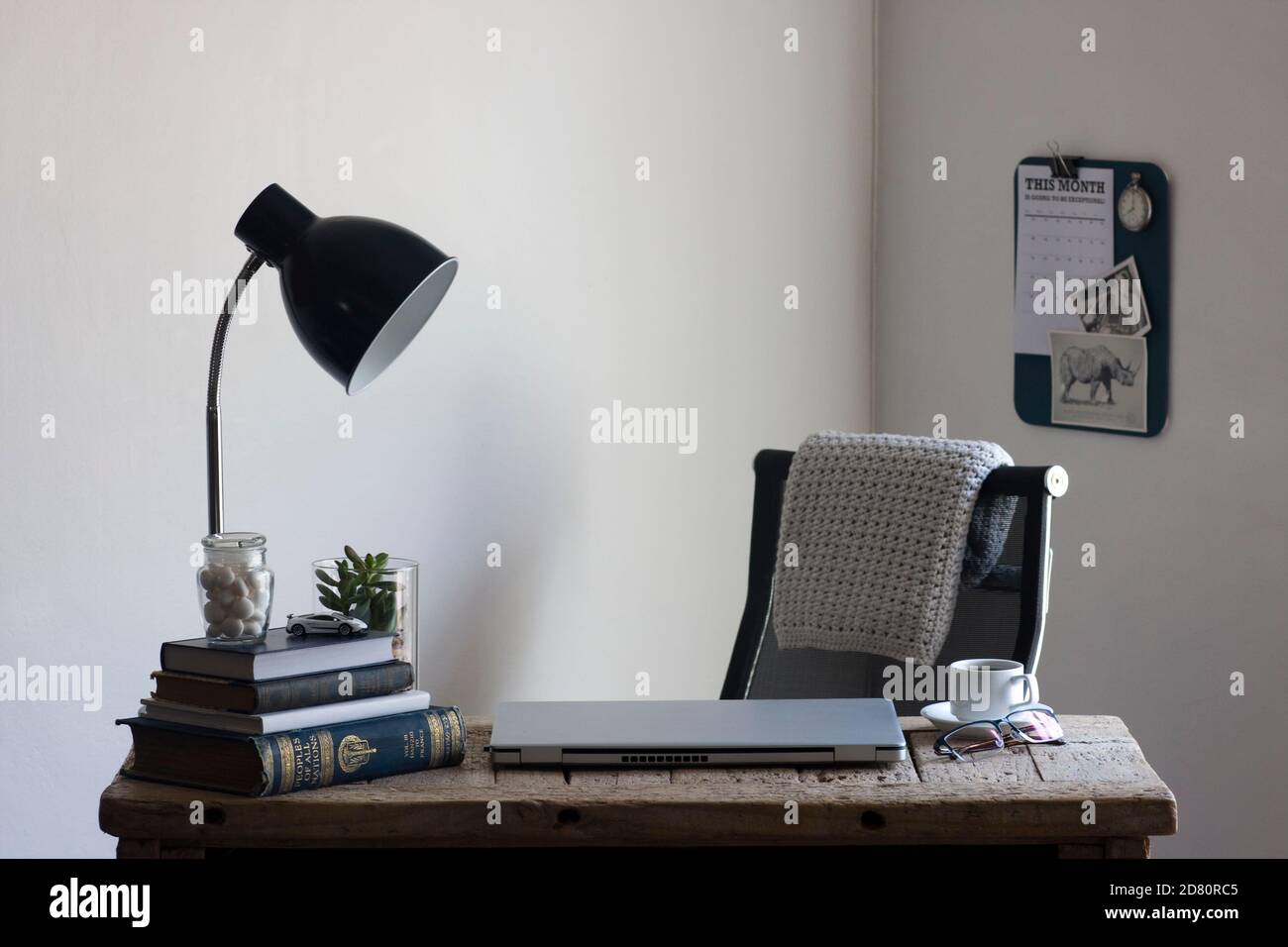 Uno spazio di lavoro per l'ufficio domestico con una scrivania in legno rigenerata, organizzata e pronta per essere utilizzata per lavorare in modo produttivo da casa. Foto Stock