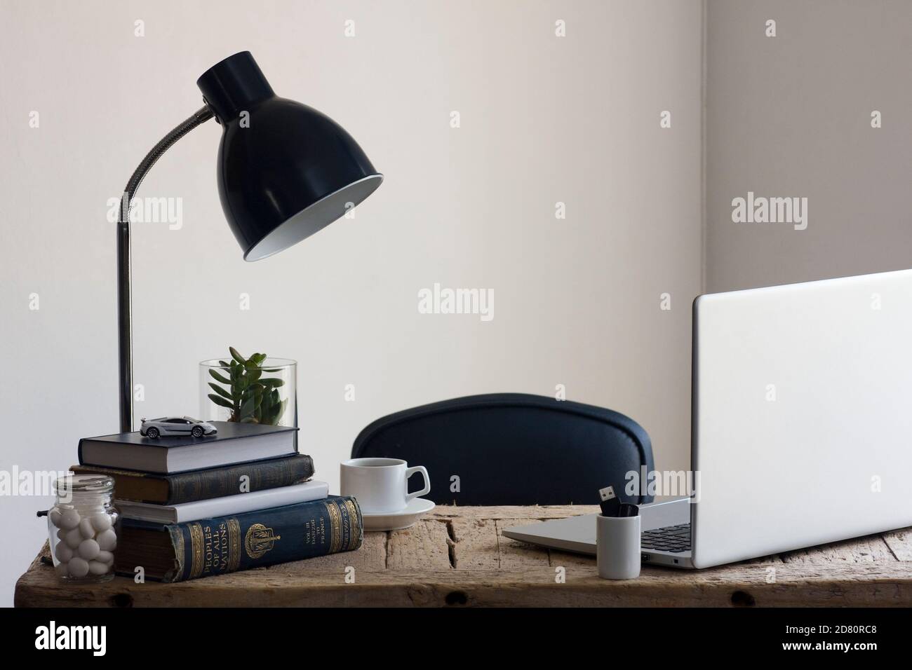 Uno spazio di lavoro per l'ufficio domestico con una scrivania in legno rigenerata, organizzata e pronta per essere utilizzata per lavorare in modo produttivo da casa. Foto Stock