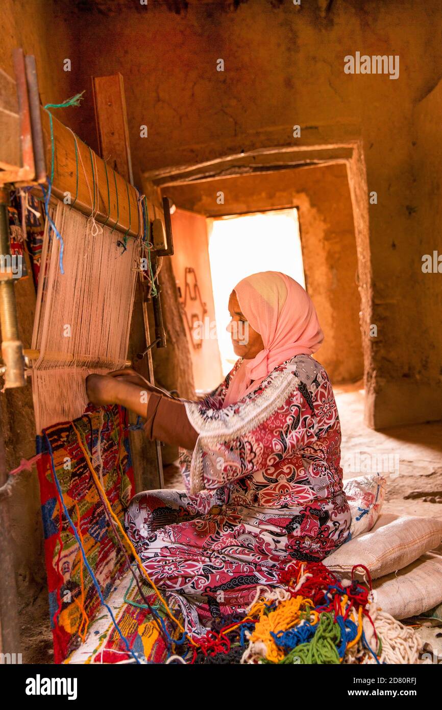 Marocco, Ksar di Ait Benhaddou, ritratto di una donna tessitrice tappeto utilizzando metodi tradizionali Foto Stock