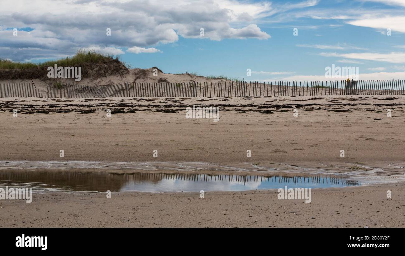 Bellissimi riflessi del cielo lungo una spiaggia con dune di sabbia in background-7 Foto Stock