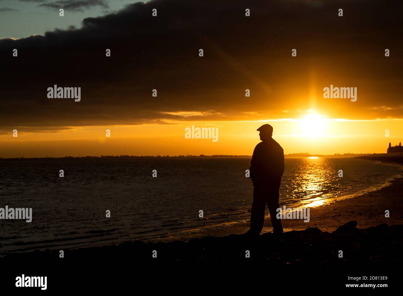Wilhelmshaven, Germania. 26 Ottobre 2020. Un uomo sta in piedi alla diga dell'airman al tramonto. Credit: Sina Schuldt/dpa/Alamy Live News Foto Stock