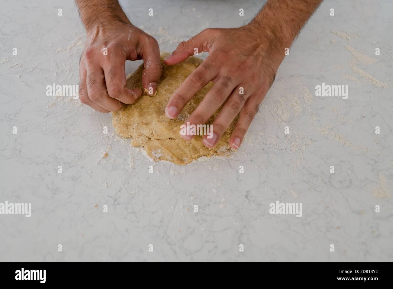 primo piano dell'impasto dei biscotti per impastare le mani dell'uomo Foto Stock