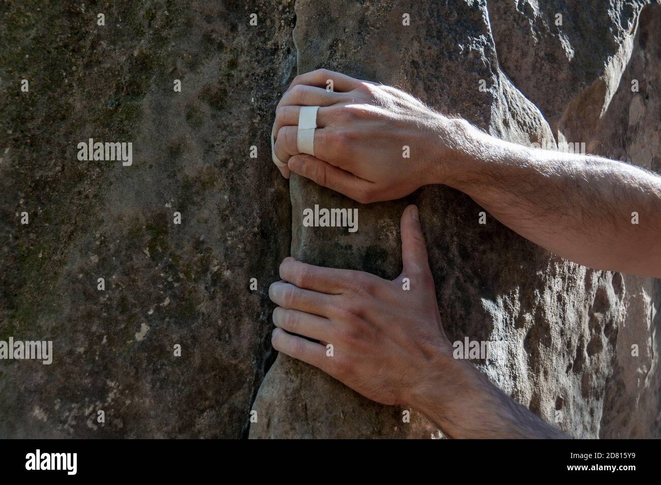 Le mani dell'arrampicatore con nastro fissato alla roccia, pronto a salire. Foto Stock