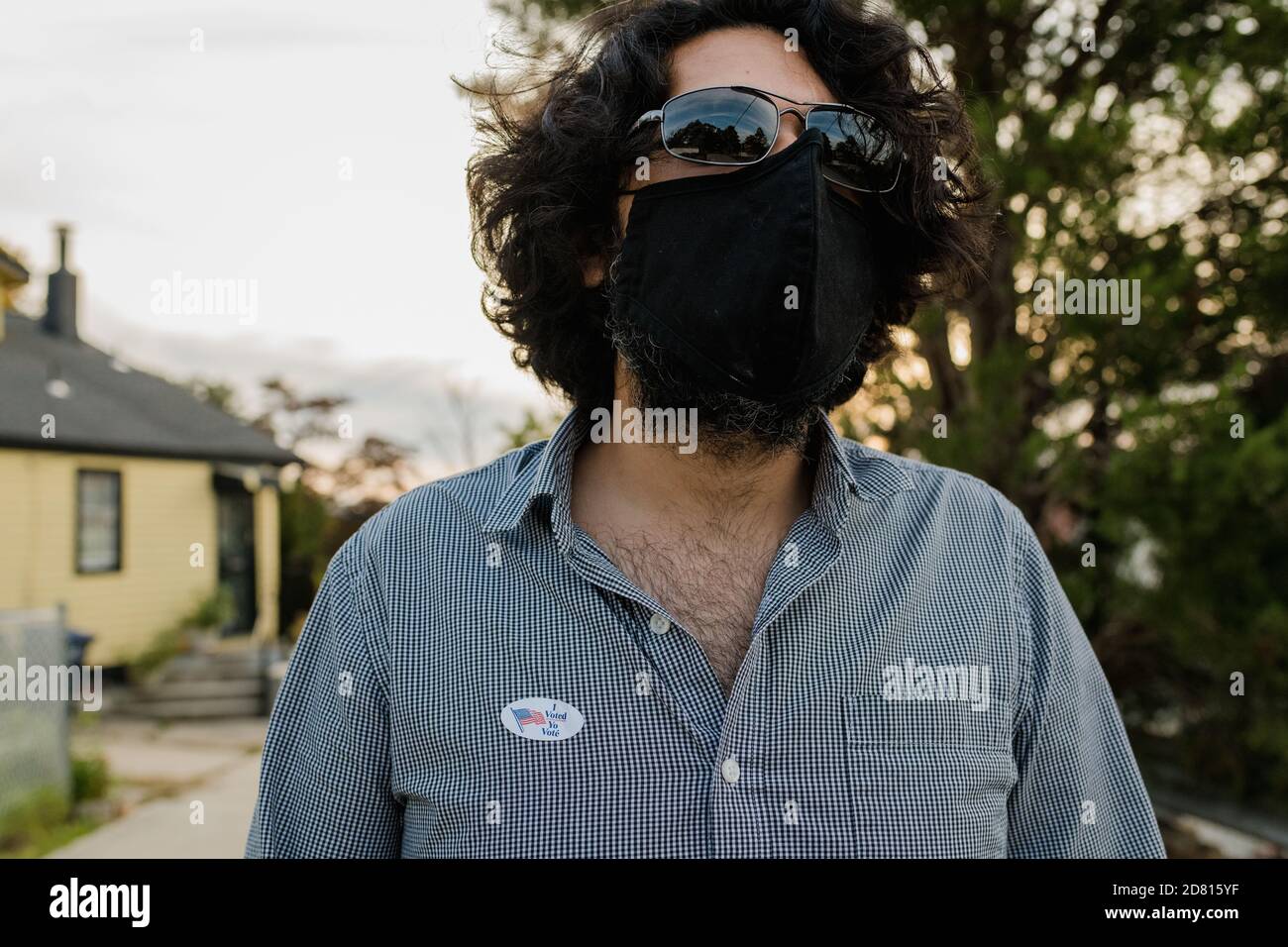 Uomo che indossa maschera protettiva e ho votato per posta adesivo Foto Stock