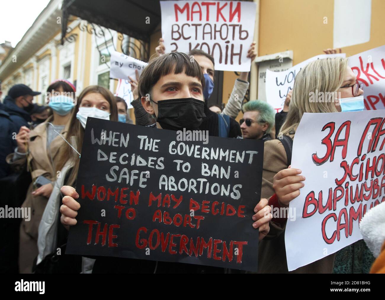 I manifestanti che indossano maschere facciali tengono i cartelli durante la manifestazione.gli attivisti ucraini protestano in solidarietà con le donne polacche contro l'inasprimento della legge sull'aborto in Polonia. Il 22 ottobre la Corte costituzionale polacca ha emesso una sentenza che limita maggiormente i diritti di aborto, causando ondate di proteste in Polonia. Foto Stock
