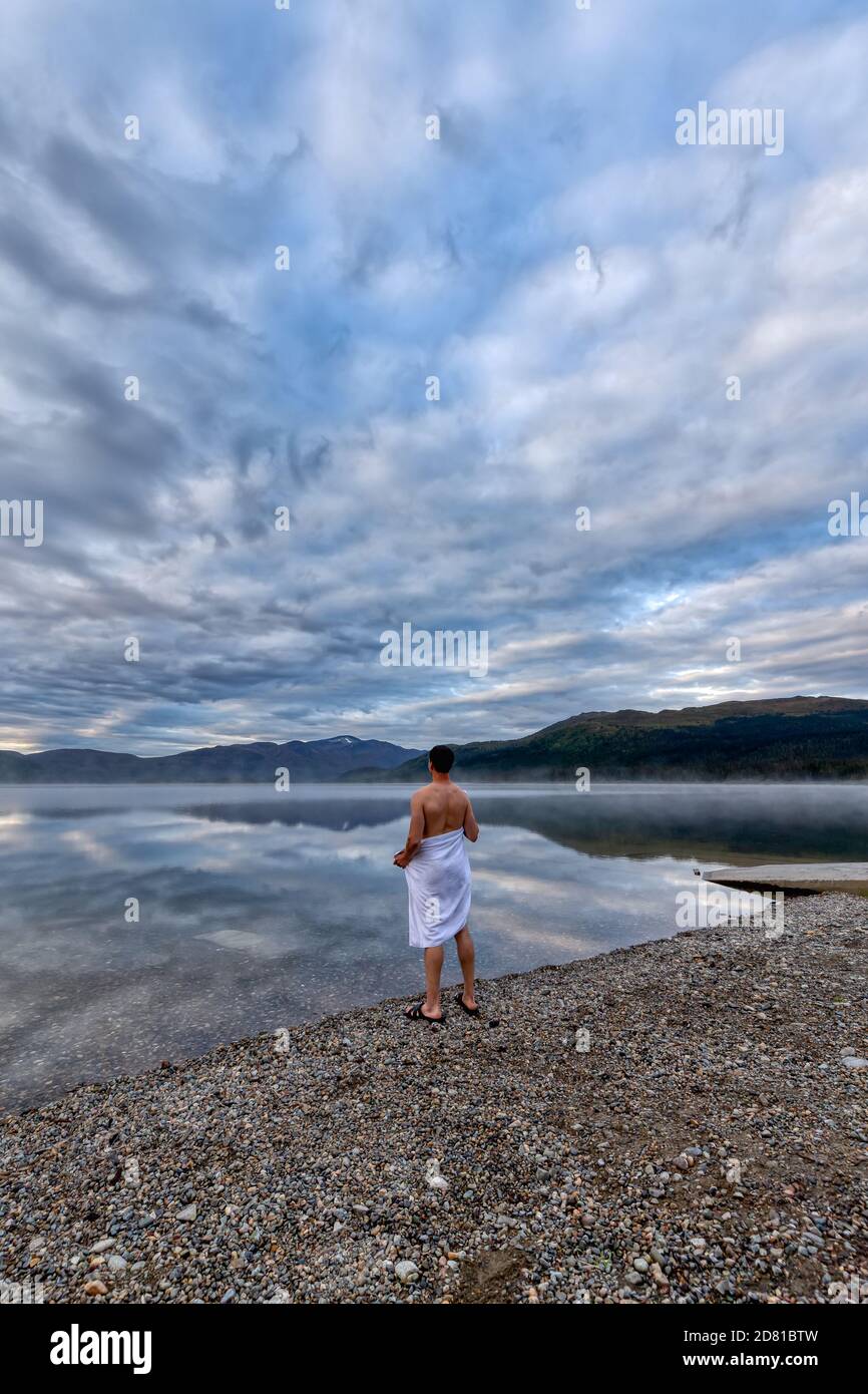 Uomo in piedi in acqua pronto a nuotare Foto Stock